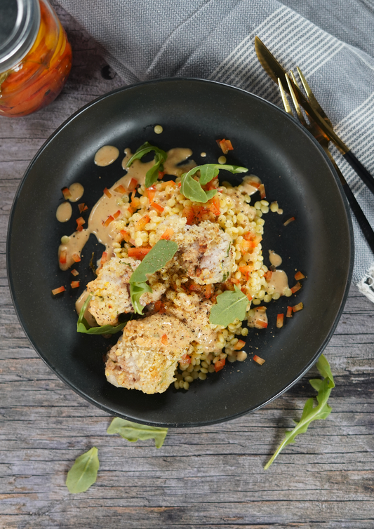 Lotte en croûte d’herbes, sauce onctueuse aux poivrons confits et roquette citronnée