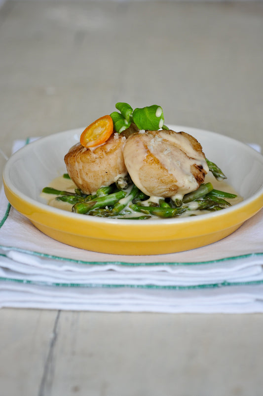 Pétoncles poêlés aux têtes d’asperges et jus crémeux au parfum d’orange