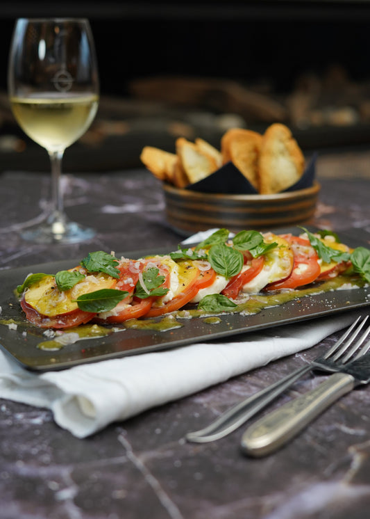 Salade de mozzarella di bufala, tomates, pêches et herbes fraîches