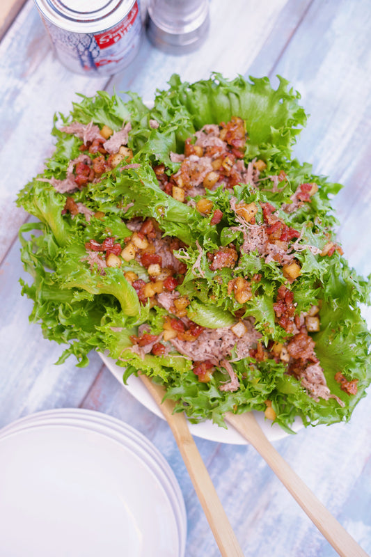 Salade tiède de confit de canard, pommes, lardons et érable
