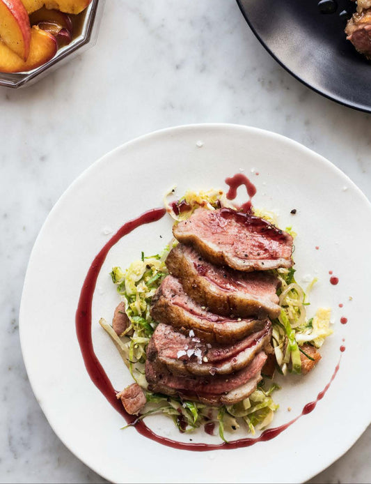 Magret de canard aux poivres concassés, réduction de vin rouge épicé