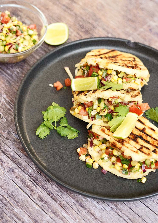 Arepas con queso, salsa de maïs grillé et légumes croquants