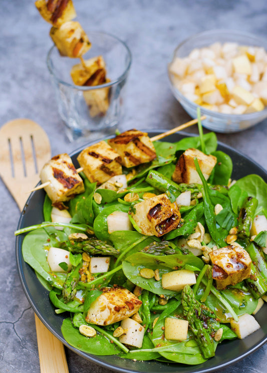 Brochettes de fromage halloumi sur nid d’épinards aux asperges, à la poire asiatique et aux pistaches