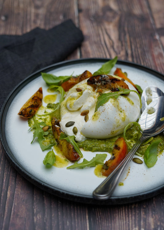 Burrata aux pêches grillées, pesto de roquettes et graines de citrouille