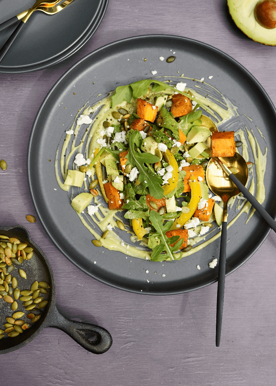 Salade tiède d’épinards et roquette, patates douces rôties au miel, graines de citrouille croquantes et crémeuse d’avocat citronnée
