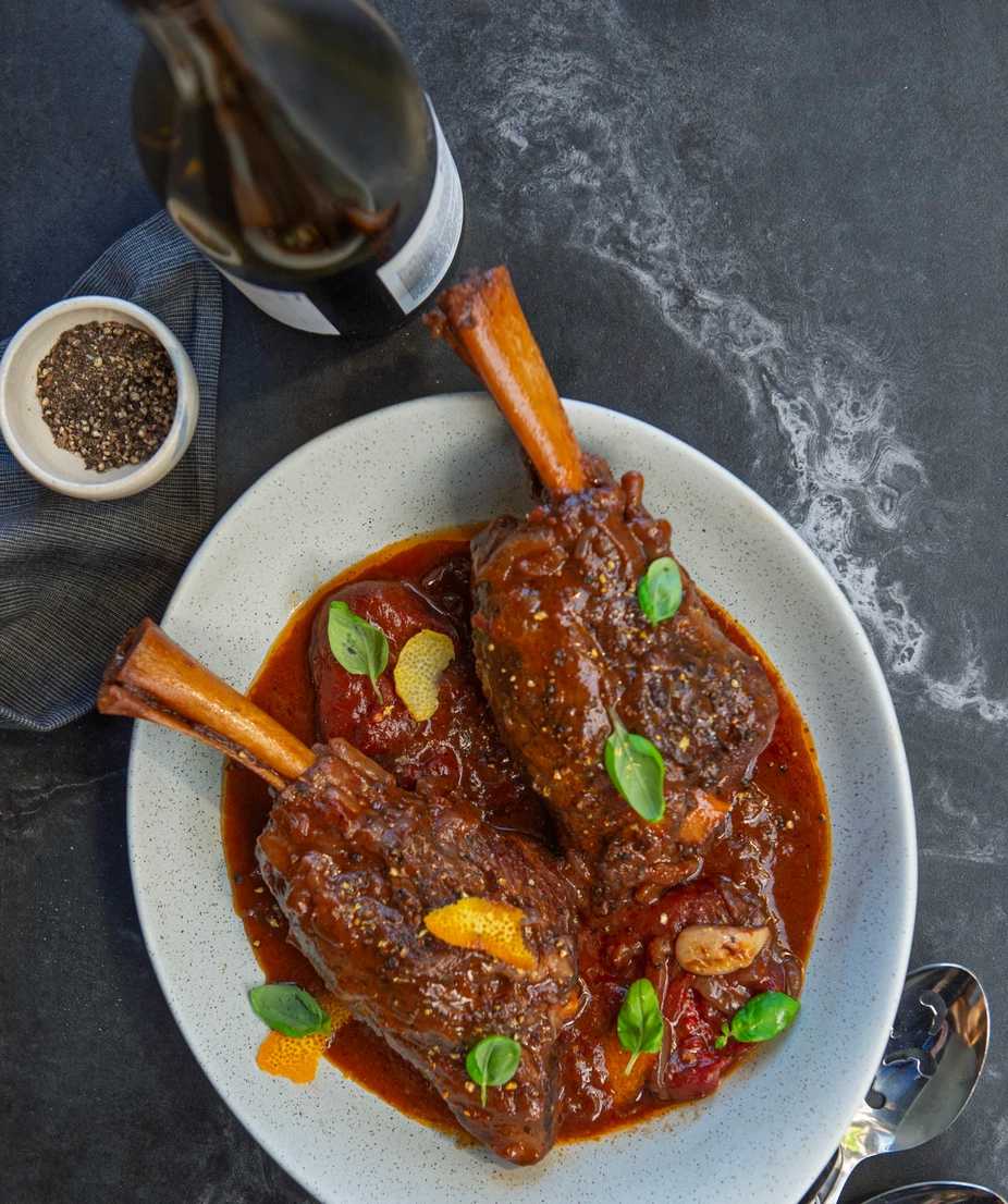 Jarrets d’agneau à l’étouffée, vin rouge, tomates et herbes fraîches