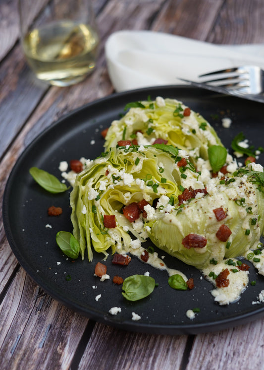 Quartiers de salade iceberg à la féta, bacon et herbes fines