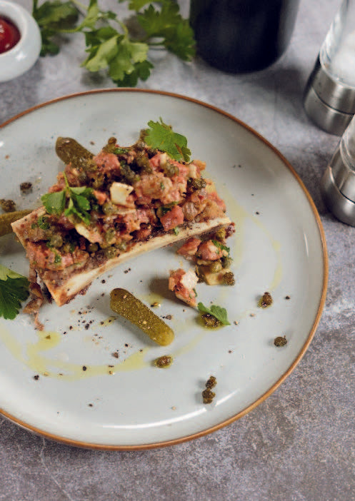 Tartare de bœuf à la moelle rôtie, tomates séchées, parmesan et herbes fraîches